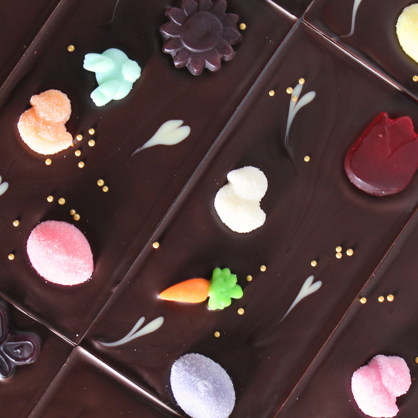 Decorative chocolate pieces with colorful candy flowers on a dark background
