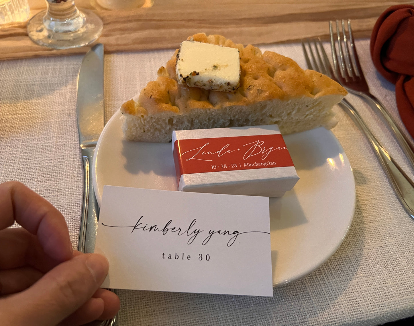 This image displays a custom belly band tailored for product packaging sitting on a plate next to bread and butter with silverware next to the plate.