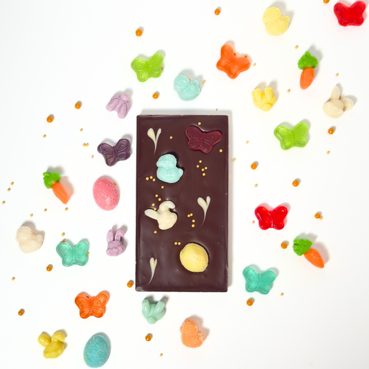 Chocolate bar with embedded colorful candy pieces on a white background