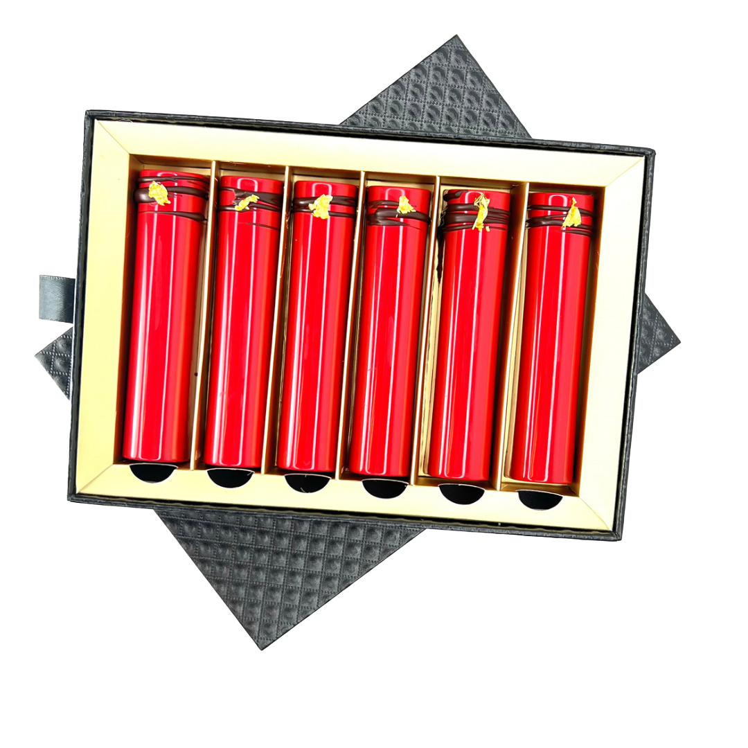 Image of Formosa Asian Twix Red chocolate bars with miso caramel and black sesame shortbread, arranged in rows with visible golden accents on top set in black box packaging with a gold interior in a set of six bars. Displayed on a white background. 