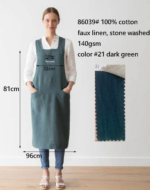 A person wearing a forest green, one-size-fits-most, 100% cotton apron with a faux linen texture, featuring the Formosa logo. The apron has pockets and does not require tying in the back.