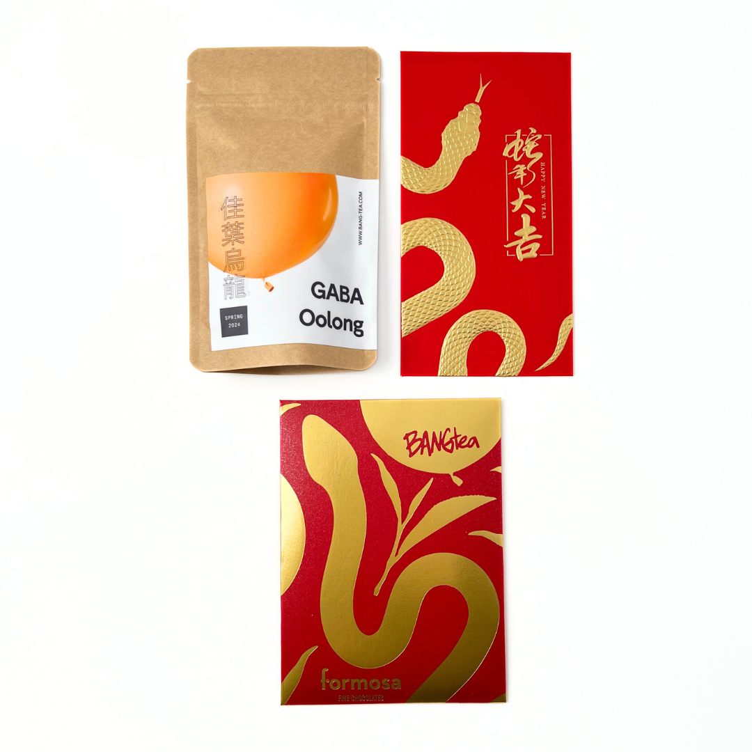 Image of the limited edition red and gold chocolate bar packaging with 'BANGtea' and 'Formosa Fine Chocolates' branding. Also included is Formosa GABA Oolong tea packet and a red and gold Year of the Snake envelope. 