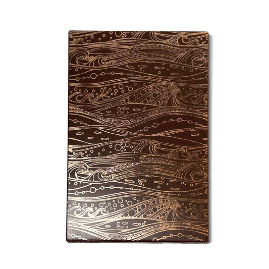 Image of Formosa Hojicha Milk bar, a rectangular chocolate bar with a decorative golden ocean motif pattern on its surface set on a white background.